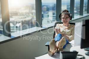 Shes the boss and she can do whatever she wants. a cheerful young businesswoman drinking coffee while sitting with her feet up on her desk inside of the office.
