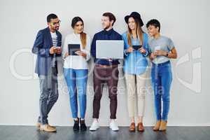 With technology being everywhere, its the future of business. a group of creative employees using wireless technology while standing in line.