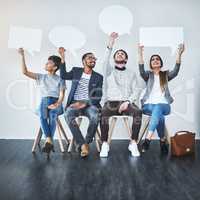 Raise your voice. Full length shot of a diverse group of businesspeople holding up speech bubbles while they wait in line.