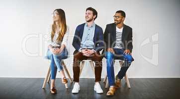 Waiting for their names to be called. a group of young businesspeople waiting in line for a job interview.