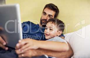 Technology provides even more ways to bond. a young man using a digital tablet with his son at home.