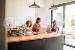 Mom helping her children with learning, education and development in online classes at home. Mother, daughter and son in the kitchen studying online, doing homework and math.