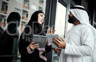 The ideas are flowing. two young businesspeople dressed in Islamic traditional clothing using their tablets on the office balcony.