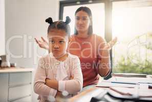 Upset, discipline and family while offended and stubborn little girl looking unhappy with her scolding mother in the background. Naughty, problem and bad child angry and ignoring her parent at home