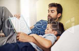 Once upon a time there lived a handsome prince... a young man reading a book with his son at home.