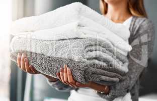 Fresh towels, ready to be packed. an unrecognizable young woman doing her laundry at home.