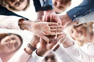 Were always here to motivate each other. Low angle portrait of a group of businesspeople putting their hands together in a huddle.