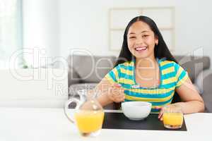 Fuel for a day filled with fun. Portrait of a happy young girl enjoying a healthy breakfast at home.