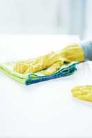 Not today, germs. an unrecognizable person wearing rubber gloves and wiping a counter at home.