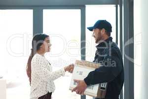 Glad you made it here safe and on time. a handsome delivery man shaking hands with a female customer.