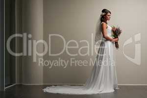 Stunning is the bride to be. Studio shot of a young beautiful bride posing against a grey background.