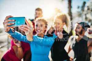 Its important to keep up your friendships. a fitness group taking a selfie while out for a run on the promenade.
