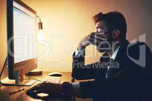 Feeling the strain. a young businessman looking stressed while working late in the office.