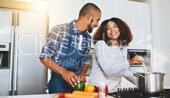 Bonding over cooking. a young couple cooking together at home.