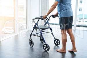 Just take a few easy steps. a unrecognizable mature man pushing a walker to help rehabilitate his movement at a clinic.