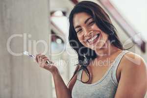 Time to shine these pearls. Portrait of an attractive young woman brushing her teeth at home.