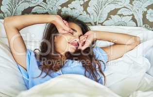 Waking up in a fabulous mood. an attractive young woman stretching while waking up in the morning.