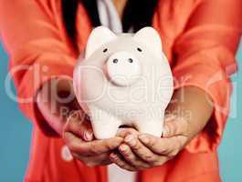 Closeup of hands holding a piggy bank with her savings and financial investments. Stylish, trendy and elegant female with future planning, looking after her wealth growth developments.