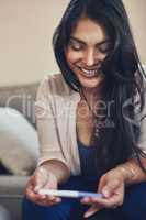 Motherhood is an experience Ive always wanted. a young woman looking happy while taking a pregnancy test at home.