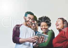 How the connected generation connect. Studio shot of a group of young people using a digital tablet together.