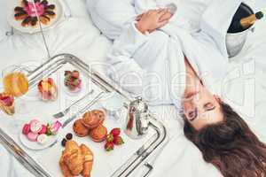 You deserve all the finer things in life. an attractive young woman enjoying a luxurious breakfast in her room.