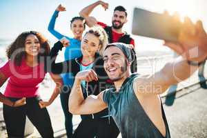 Its a blast to work out with friends. a fitness group taking a selfie while out for a run on the promenade.