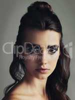 Be that weird, different and magical person you are. Studio shot of an attractive young woman wearing bold eye makeup.