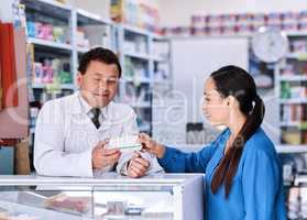 Make sure you take the correct dosage. a male pharmacist helping a female customer in a pharmacy.