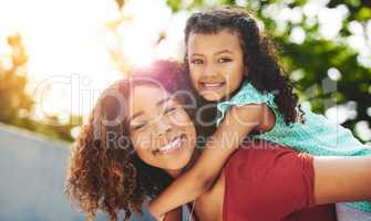 The best time is mommy and me time. a happy little girl and her mother enjoying a piggyback ride in their backyard.