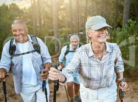 Hiking retired, elderly and senior friends or tourists in forest or mountains for fitness, health and wellness at old age. Diverse group of active mature pensioners outdoors on weekend hike in nature