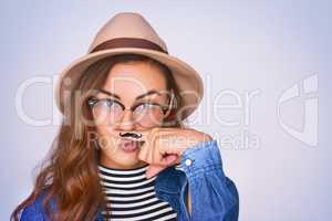 Movember here I come. Studio shot of a beautiful young woman posing against a purple background.