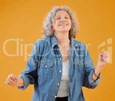 Smiling mature woman celebrating, dancing and being carefree, happy and excited for retirement. Portrait of positive, trendy and funky positive senior lady free spirit, dance and having fun in studio
