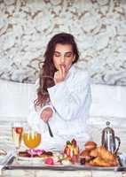 Theres nothing like a good breakfast to make your day. an attractive young woman enjoying a luxurious breakfast in her room.