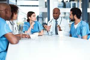 Planning the way forward. a group of medical practitioners having a meeting in a hospital boardroom.