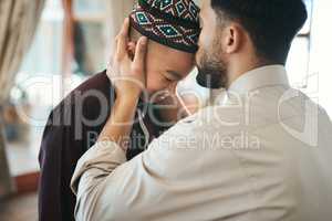 Muslim father, parent or man kissing his son on the forehead, bonding and showing affection at home. Happy, smiling and Arab boy embracing, celebrating traditional holiday and being peaceful with dad