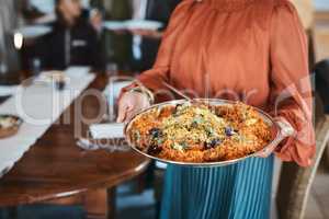 Food, dinner and consumables with a traditional paella dish in the hands of a woman at home. Closeup of a bowl of spanish sea food, ready to serve and feed hungry family for lunch or healthy supper