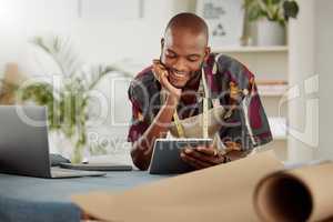Checking an online order of fashionable style on his company website or internet app. Fashion, design and clothing industry with a trendy tailor thinking working on a tablet in his studio or workshop