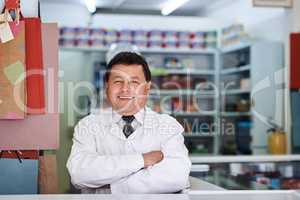 Hes here to improve your health. Portrait of a male pharmacist in a pharmacy.