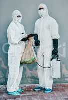 Scientists disinfect isolated and dangerous area. Medical staff protect themselves with sterile equipment. Healthcare workers clean while wearing safety uniform to stop the spread of a virus.