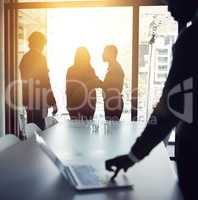 Planning strategy for a successful and bright future with a team of business people talking in a boardroom meeting with flare. Backlit group of corporate professionals discussing in the office