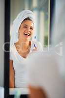 Just look at that sparkling smile. an attractive young woman brushing her teeth at home.