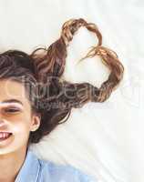 Blissful mornings. High angle shot of an attractive young woman relaxing on her bed.