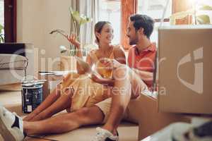 Home owner couple taking a break from painting, moving into new house or remodeling living room interior design. Husband, wife searching home improvement ideas online with tablet on a relaxing day