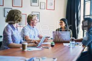 Nothing gets results like teamwork. a diverse group of businesspeople having a meeting in a modern office.