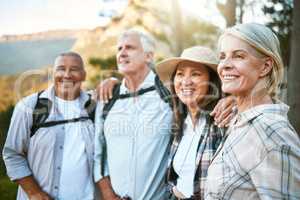 Hiking, adventure and exploring with a group of senior friends and retired adults enjoying a hike or walk outdoors in nature. Enjoying the view while on a journey of discovery in the forest or woods