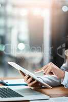 Browsing around for some information she needs. Closeup shot of an unrecognizable businesswoman using a digital tablet in an office.