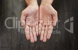 All you need is a lending hand. Studio shot of an unrecognizable persons open hands shown against a dark background.