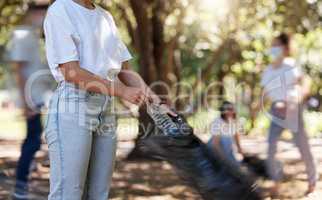 Volunteers helping collect trash on community cleanup project outdoors, collecting plastic and waste to recycle. Woman cleaning environment, picking up dirt in street. People uniting to make a change