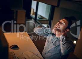 Overtime is starting to build tension in his neck. a young businessman suffering with neck pain while working late in an office.