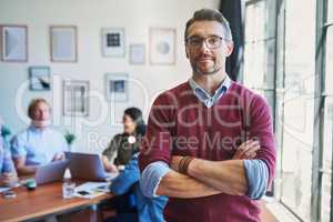 Confident leaders create confident teams. Portrait of a confident mature man with his team in the background of a modern office.